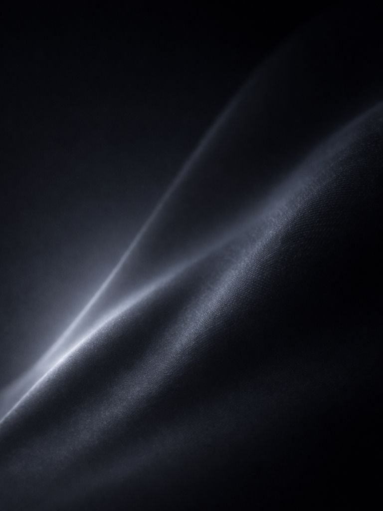 A soft fold of dark technical material catching a single line of light.
